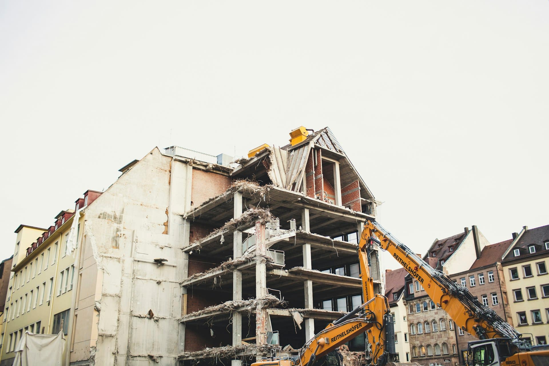 Excavator demolishing a multi-storey building